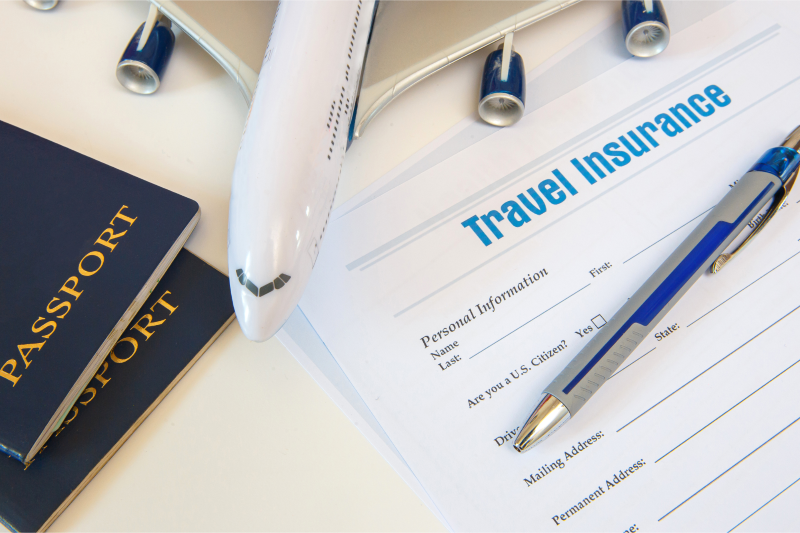 Travel insurance document with a pen and two passports on a table